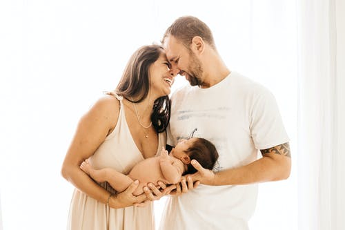 抱着婴儿的笑夫妇的照片 · 免费素材图片