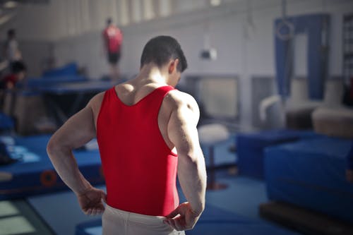 宽敞的体育馆里的男体操运动员 · 免费素材图片
