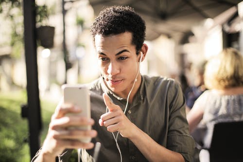 选择性聚焦照片的男人穿着棕色衬衫的按钮举行电话交谈 · 免费素材图片