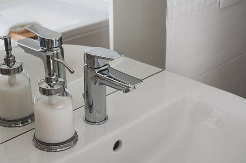 白色陶瓷水槽与不锈钢水龙头的特写照片 · 免费素材图片