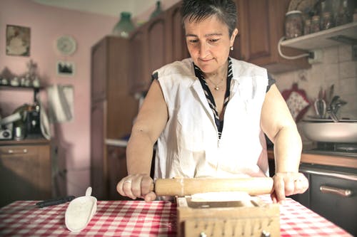 女高管滚动面团在厨房里 · 免费素材图片