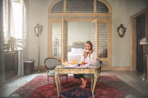 女人在豪华酒店房间里享用早餐 · 免费素材图片