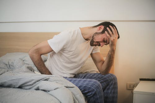 年轻人在早上遭受头痛的睡衣 · 免费素材图片