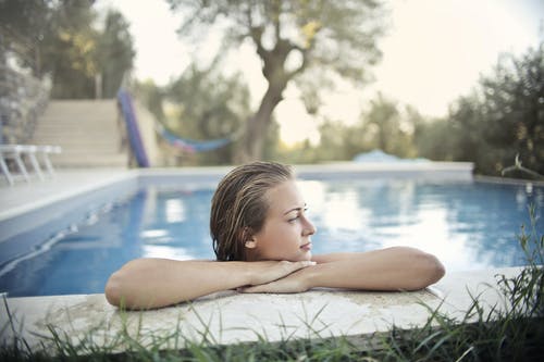在夏天在游泳池边休息的轻松的女人 · 免费素材图片