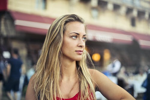 女人在红色背心看着别处的选择性焦点肖像照片 · 免费素材图片