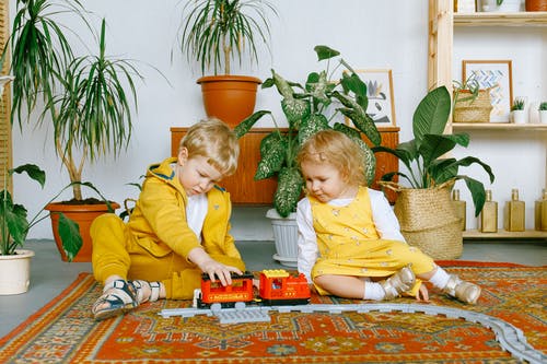 可爱的小男孩和女孩玩玩具火车 · 免费素材图片