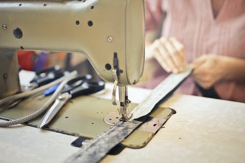 裁缝缝制缝纫机上的衣物 · 免费素材图片
