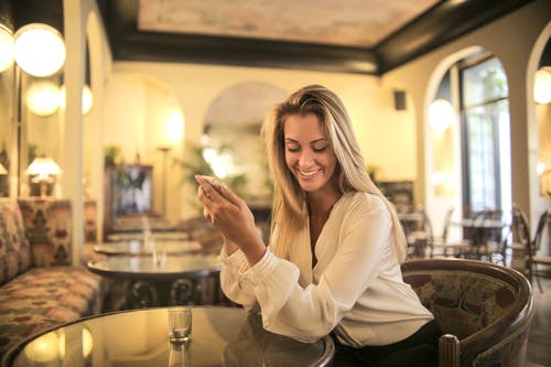 性格开朗的女性在优雅的酒吧喝一杯 · 免费素材图片