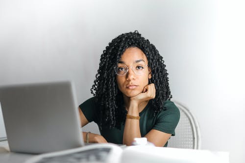 在家使用膝上型计算机的严肃的种族少妇 · 免费素材图片