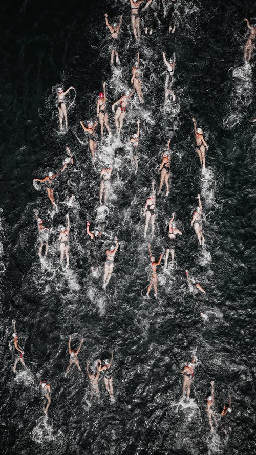 人们在比赛中在溅海里游泳 · 免费素材图片