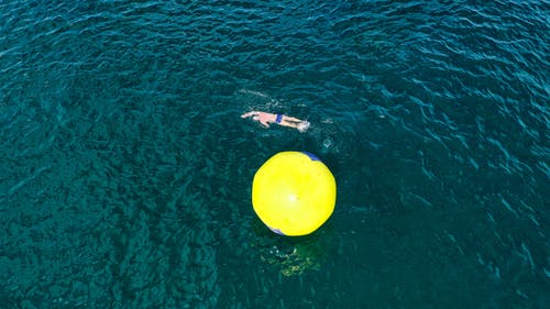 充气浮标周围游泳的人 · 免费素材图片