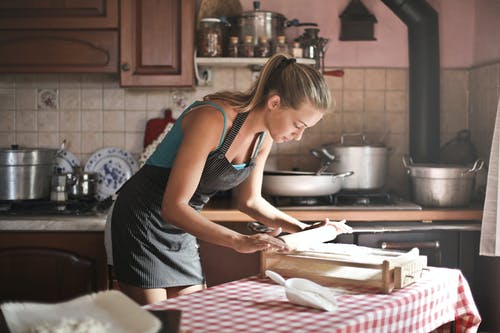 少妇烘烤的辗压面团在厨房里 · 免费素材图片