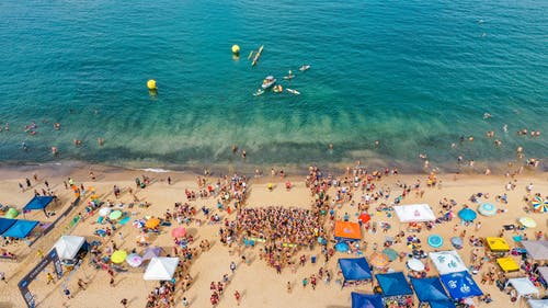 游泳比赛期间海洋拥挤的海岸 · 免费素材图片