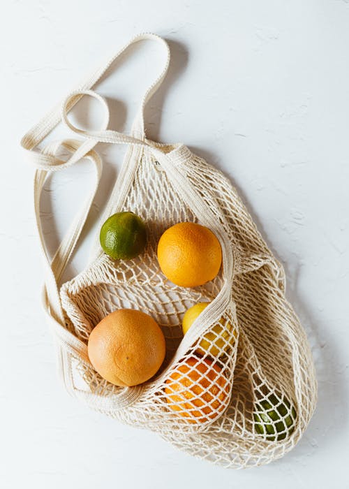 什锦的柑橘类水果在白色表面上的棉麻袋 · 免费素材图片