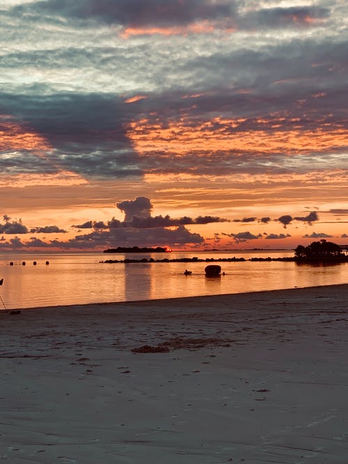 空旷的海滩上令人叹为观止的日落 · 免费素材图片