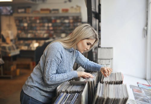 从音乐商店选择唱片的灰色毛衣的选择性焦点侧视图照片女孩 · 免费素材图片