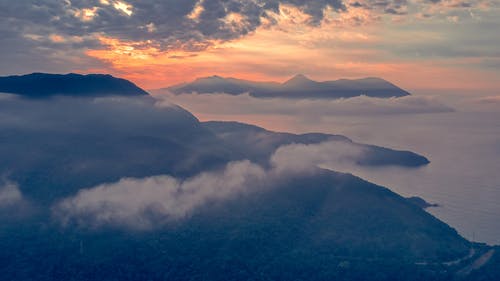 日落时薄雾笼罩的山峰 · 免费素材图片