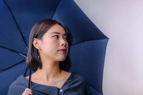 女人看着别处的黑顶拿着伞的肖像照片 · 免费素材图片