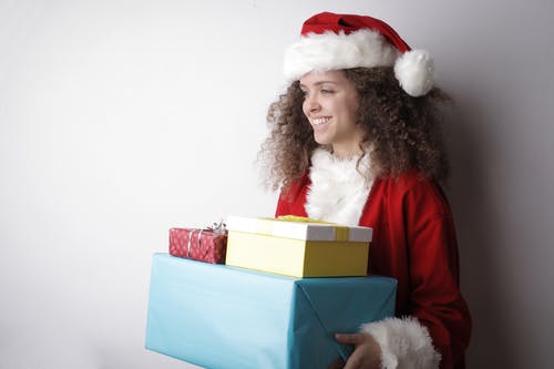 圣诞老人服装与圣诞节礼物的高兴的女人 · 免费素材图片