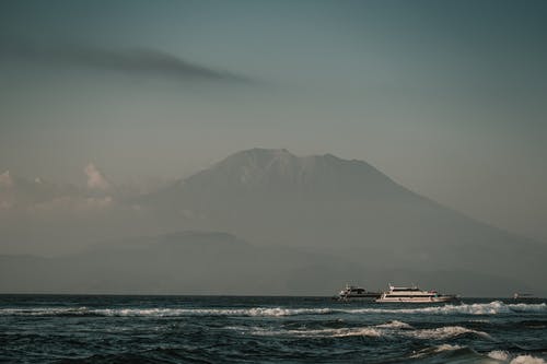 多云的天空，在高山和大海与帆船 · 免费素材图片