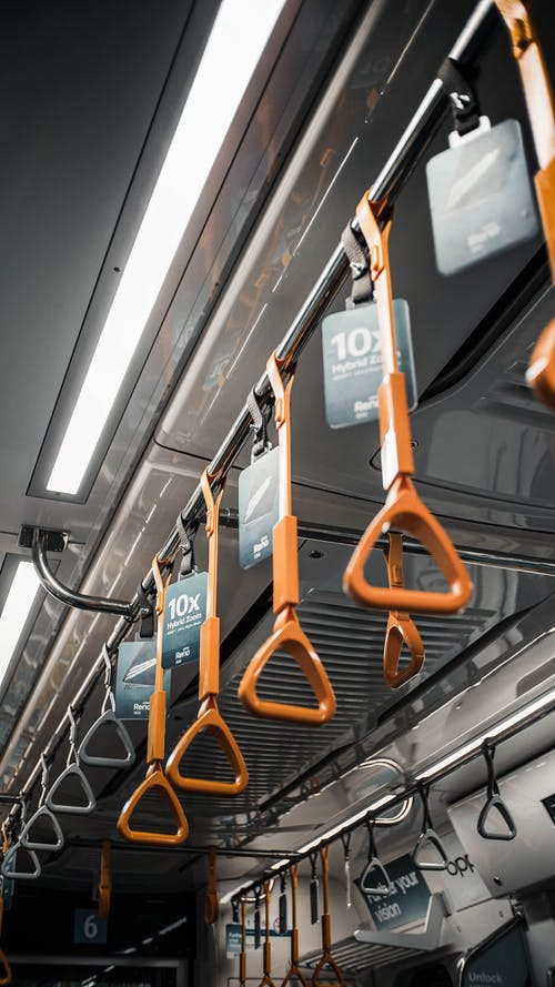 在公共交通工具上悬挂橙色把手 · 免费素材图片