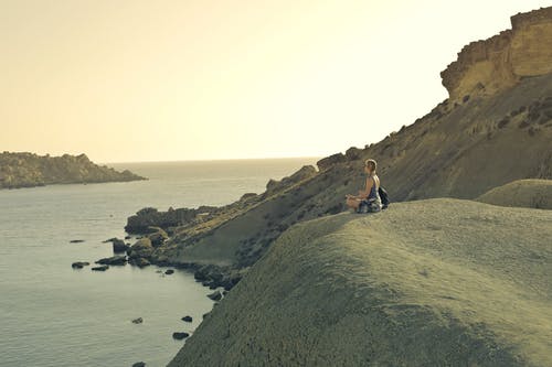 女人坐在山崖上 · 免费素材图片