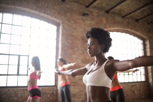 与其他女运动员在现代健身工作室自信适合种族的女人训练 · 免费素材图片