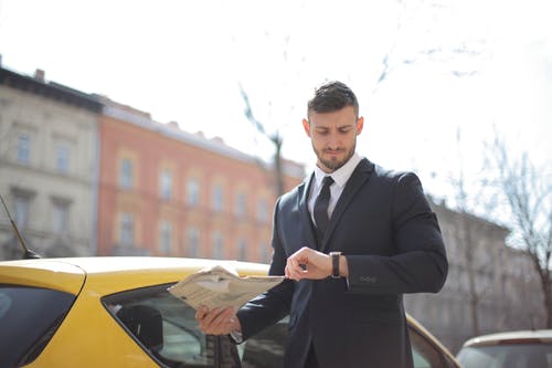 站在黄色的汽车旁边的黑色西装的男人 · 免费素材图片