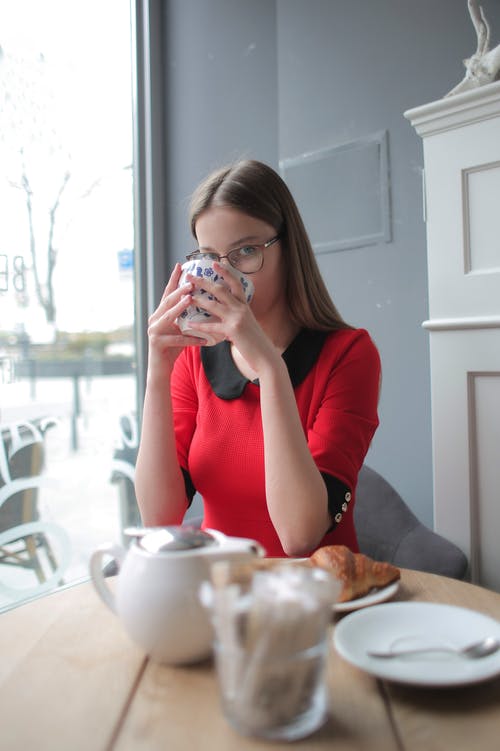 红色长袖衬衫喝绿茶的女人 · 免费素材图片