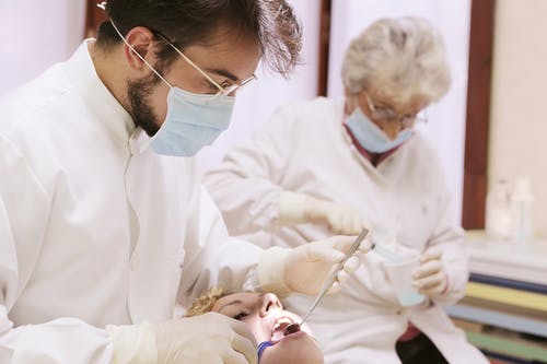牙医看着女人的嘴 · 免费素材图片