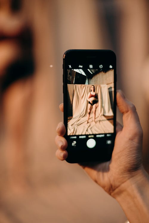在黑色智能手机上捕获的一个女人的照片 · 免费素材图片