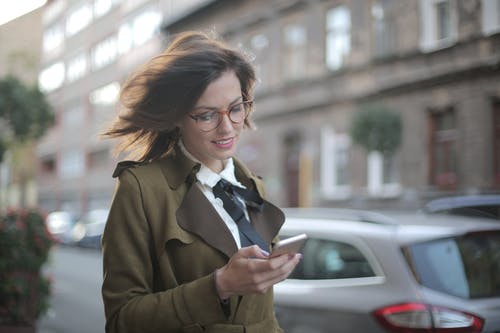 在大街上使用智能手机的时尚成年女性 · 免费素材图片