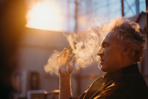 一名男子吸烟香烟的侧视图照片 · 免费素材图片