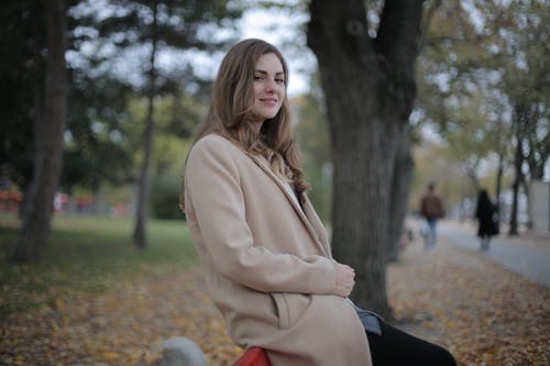 在秋天的公园里冷的高兴年轻女子 · 免费素材图片