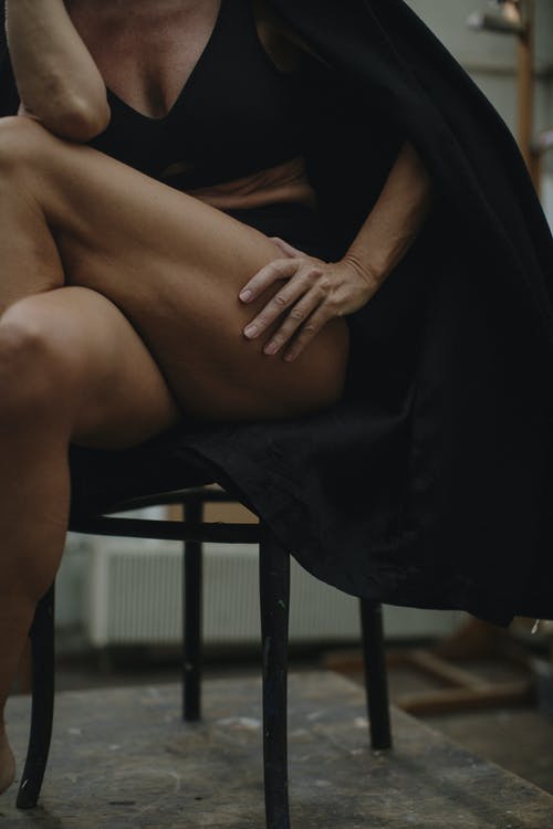 坐在黑色椅子上的黑色礼服的女人 · 免费素材图片