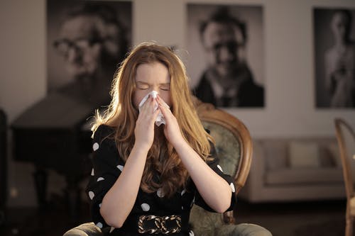 生病的女人用纸巾擦鼻子 · 免费素材图片