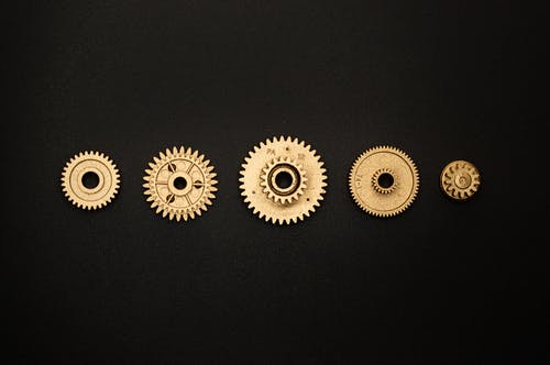 黑色表面上的金色圆形齿轮 · 免费素材图片