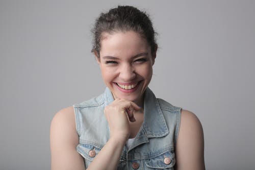 蓝色牛仔布按钮背心的小女孩微笑着 · 免费素材图片