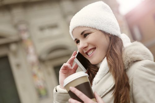 有魅力的女人，用外卖咖啡讲城市的智能手机 · 免费素材图片
