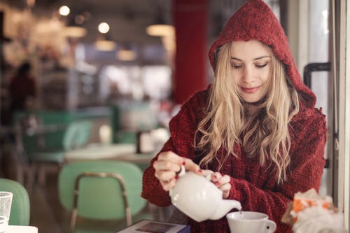 拿着白色陶瓷茶杯的红色毛衣的女人 · 免费素材图片
