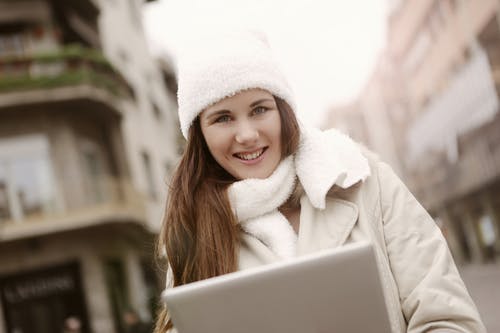 高兴的女人在大街上使用平板电脑 · 免费素材图片
