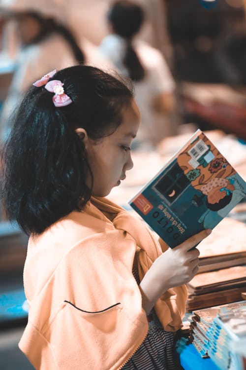 女孩抱着一个故事书 · 免费素材图片