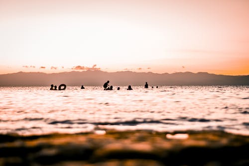 人们在日落海滩上的剪影 · 免费素材图片