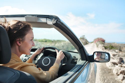 棕色夹克驾驶汽车的女人 · 免费素材图片