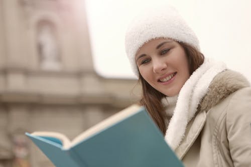 高兴的女人享受在城市的街道上阅读 · 免费素材图片