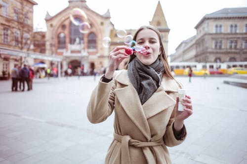 棕色外套吹泡泡的女人 · 免费素材图片