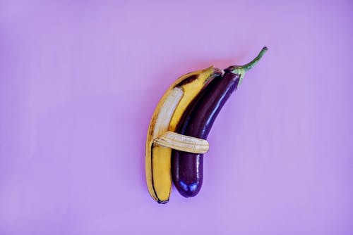 香蕉和紫色表面上的茄子 · 免费素材图片