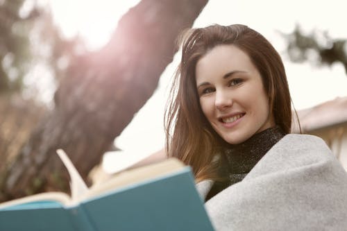 正面妇女阅读书在城市公园 · 免费素材图片