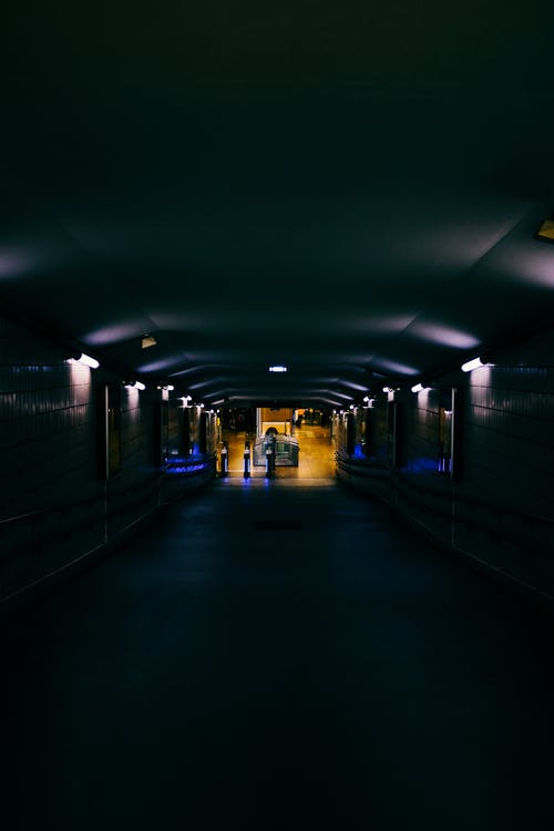 不可识别的女人，晚上站在黑暗的隧道 · 免费素材图片