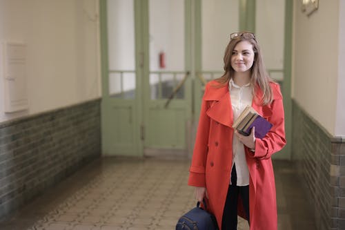 聪明的女学生，书和背包在大学的走廊里 · 免费素材图片